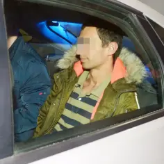 Kajetan Poznański w zielonej kurtce z pomarańczowym kołnierzem i w pasiastej koszulce siedzi z tyłu samochodu.
