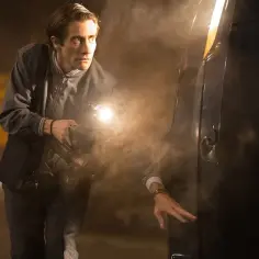 Jake Gyllenhaal w jednym z filmów, z kamerą i latarką, w dymie.